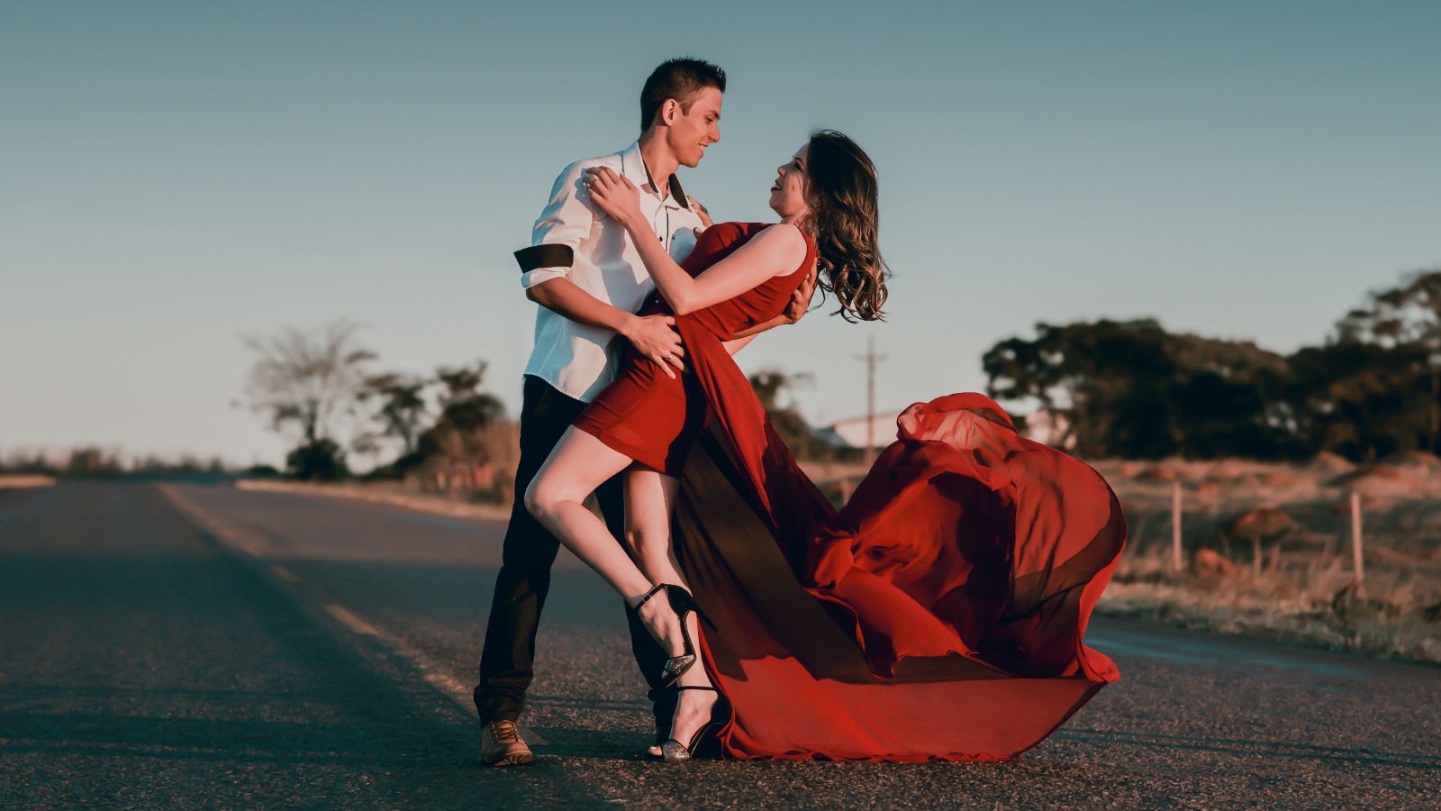 Foto “Man and Woman Doing Dance Post in Concrete Road at Daytime” von Silvio Barbosa